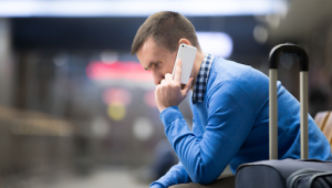Homem no celular em aeroporto