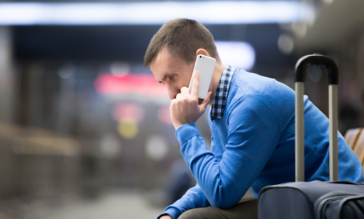 Homem no celular em aeroporto